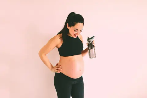 Aktywna przyszła mama z dużym brzuchem, która dba o nawodnienie. W ciąży może być potrzebna insulina, ale aktywność fizyczna i dieta to podstawa.