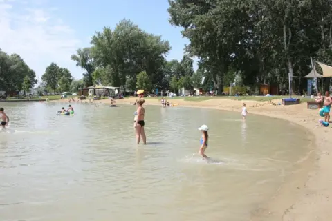 Ludzie kąpią się i bawią na piaszczystej plaży nad jeziorem. Gdzie jest Balaton? Węgry, Szigliget.