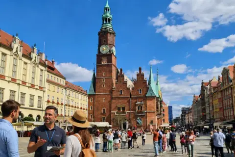 Spacer opowiada o historii placu Wolności we Wrocławiu, podziwiając zabytkową architekturę i gwarne życie miasta.