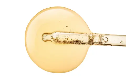 Goldgelbes Serum mit Pipette, das für strahlende Haut sorgt. Vitamin C Haut vorher-nachher: Ein Tropfen für sichtbare Ergebnisse.