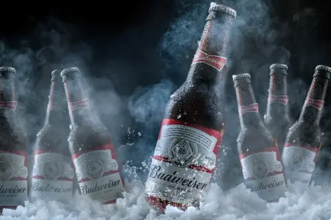 Butelki piwa Budweiser w lodzie i dymie. Czy można pić piwo które zamarzło? To pytanie pozostaje otwarte, ale zimne piwo zawsze smakuje wybornie.