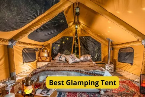 Wnętrze luksusowego namiotu glampingowego z wygodnym łóżkiem, piecykiem i nastrojowym oświetleniem. To jest właśnie glamping co to znaczy – komfort na łonie natury.