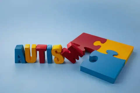Kolorowe litery układają się w napis AUTISM, obok leżą niedopasowane elementy układanki. Czy to symbol poszukiwania leku na autyzm?