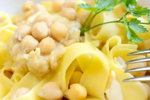 Ciceri e tria, un piatto pugliese con pasta fresca e ceci, guarnito con prezzemolo.