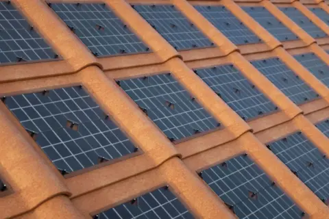 Tegole solari integrate su un tetto di tegole rosse, catturano l'energia del sole per un futuro sostenibile.
