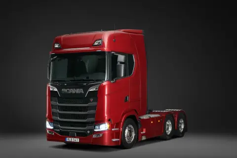 Un puissant camion Scania rouge, modèle V8, prêt pour de longues routes.