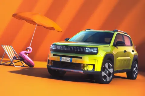 Nowy Fiat Panda w jaskrawym kolorze, gotowy na wakacje. Obok leżak, parasol i dmuchany flaming.