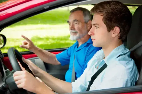 Joven conductor aprende a manejar con su instructor. ¡Con 17 años ya se puede sacar el carnet de conducir!