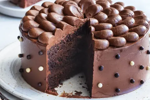En saftig chokladtårta med chokladfrosting och dekorationer av chokladkulor. Perfekt för alla som älskar choklad och letar efter ett gott chokladtårta recept.