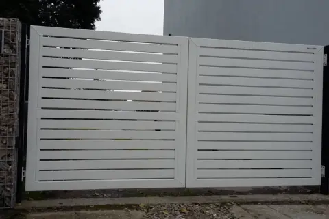 Nowoczesna, biała brama z poziomymi lamelami. Po lewej stronie widoczny enkoder, co to za urządzenie?