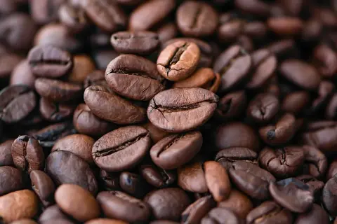 Chicchi di caffè qualità arabica tostati, un primo piano che evoca profumo e gusto intenso.