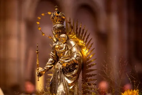 Goldene Statue der Maria mit Kind, gekrönt und mit Sternenhalo. Ein Symbol für Hoffnung und Glauben, das viele Namen trägt.