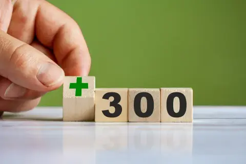 Dłoń układa kostkę z zielonym plusem obok kostek z napisem 300. Czy to 300 plus do jakiego wieku?