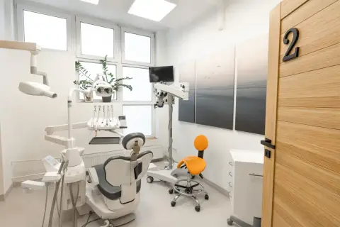 Nowoczesny gabinet stomatologiczny z fotelem, mikroskopem i drzwiami z numerem 2.