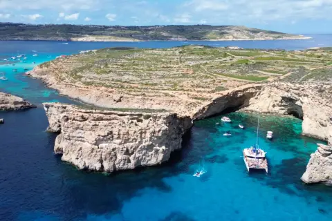 Malta czy warto? Błękitna Laguna na Gozo zachwyca turkusową wodą i skalistymi klifami. Idealne miejsce na rejs katamaranem.