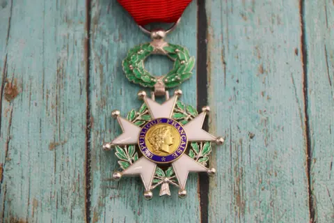 Médaille de la Légion d'Honneur, symbole d'un grand avantage de la légion d'honneur, sur fond de bois bleu délavé.
