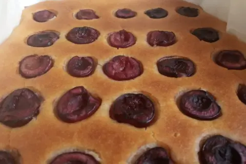 Puszyste ciasto z czereśniami, z widocznymi połówkami owoców zatopionymi w złocistym cieście. Idealne na letnie popołudnie.