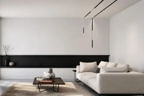 Nowoczesne oświetlenie do salonu aranżacje: minimalistyczny salon z beżową sofą, czarną półką i designerskimi lampami wiszącymi.