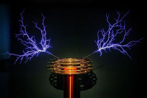 Cewka Tesli generuje fioletowe wyładowania elektryczne przypominające drzewa.