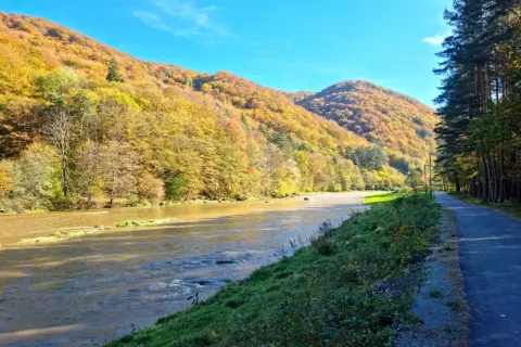 Jesień nad Popradem. Ścieżka rowerowa wzdłuż rzeki, góry w złotych barwach. Idealne miejsce na **velo Poprad**.
