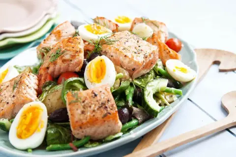En härlig sallad nicoise med lax, ägg, gröna bönor och oliver. Perfekt för en lätt lunch.