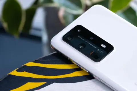 Biały smartfon z aparatem Leica na pokładzie, działający na systemie emui 10.1, leży na ozdobnej powierzchni.