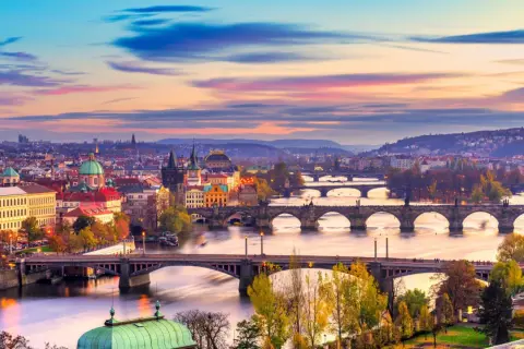 Praga o zachodzie słońca, z wieloma mostami na Wełtawie. Idealne miejsce, gdzie jechać w listopadzie, by poczuć magię miasta.