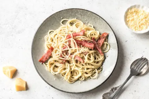 Ein Teller Spaghetti Carbonara mit Speck und Parmesan. Perfekt für die Frage: welcher Wein zu Carbonara.