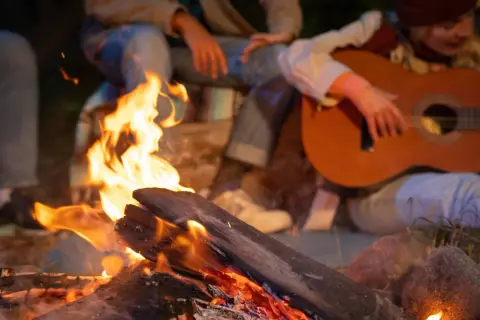 Przy ognisku, kiedy rum zaszumi w głowie, dziewczyna gra na gitarze, a przyjaciele siedzą blisko, ciesząc się ciepłem i muzyką.