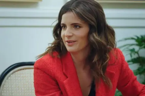 Ana Iris Simón, con su chaqueta roja, comparte ideas en una conversación animada.