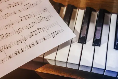 Nuty muzyczne leżące na klawiaturze keyboardu.