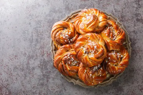 En bricka med nybakade kanelbullar, perfekta att baka i varmluftsugn. Strösslade med pärlsocker.