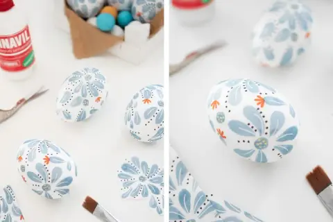 Lavoretti uova di polistirolo decorate con fiori azzurri e arancioni, pronte per Pasqua.