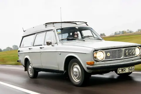 Grå Volvo 145 Express med takräcke kör på en väg.