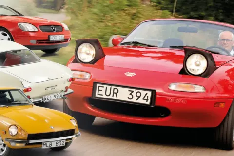 En samling klassiska sportbilar: en röd Mazda Miata med pop-up-strålkastare, en gul Datsun 240Z, en vit Volvo P1800 och en röd Mercedes-Benz SLK.