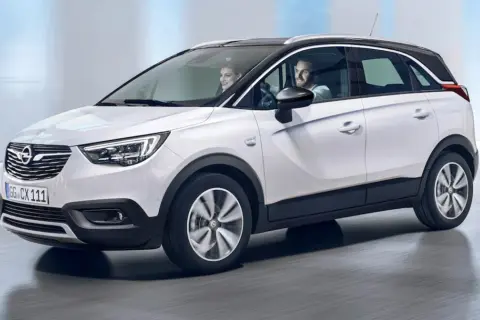 Biały Opel Crossland z parą uśmiechniętych ludzi w środku. Sprawdź atrakcyjną opel crossland cena!