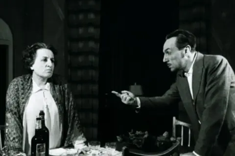 Una donna e un uomo discutono animatamente. La scena evoca la **Filumena Marturano storia vera**, un dramma di vita e di scelte difficili.