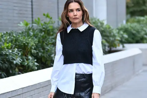 Donna con camicia bianca e gilet nero, la camicia si mette dentro o fuori, con gonna in pelle.