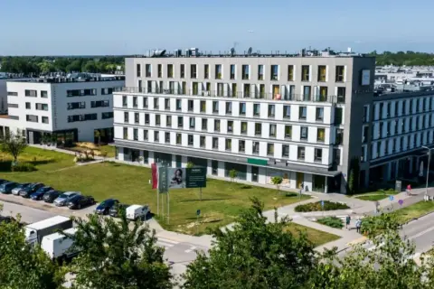 Nowoczesny waw airport hotel z parkingiem i zielonym otoczeniem.