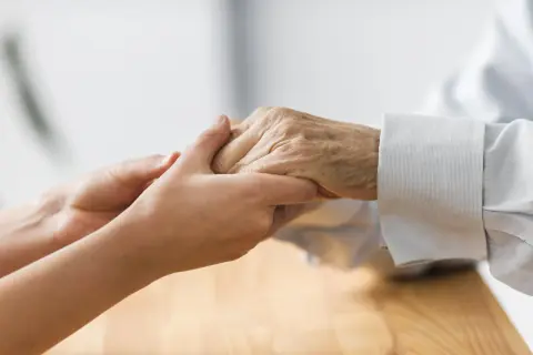 Deux mains se serrent, symbolisant la mise sous protection d'une personne âgée. Un geste de tendresse et de soutien.