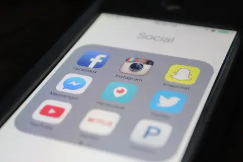Ikona Snapchat na ekranie telefonu, obok Facebook, Instagram. Zastanawiasz się, snapchat co to? To popularna aplikacja społecznościowa.