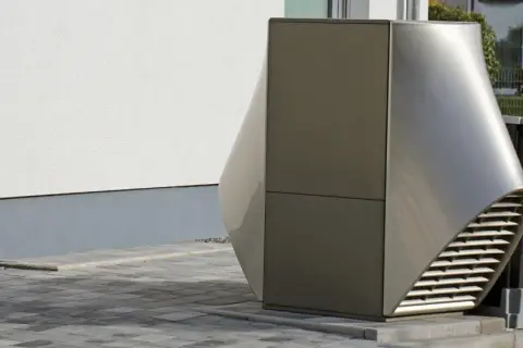 Nowoczesna, futurystyczna obudowa pompy ciepła r32 o aerodynamicznym kształcie, stojąca obok drewnianej skrzyni na śmieci.