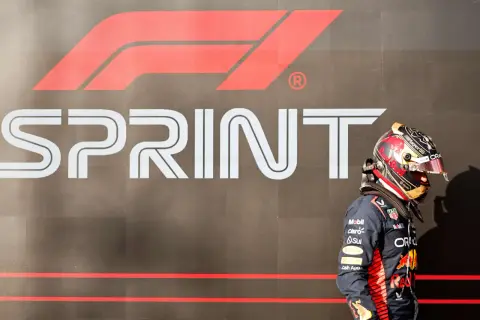Piloto de F1 con casco decorado, frente al logo de "SPRINT" de la Fórmula 1.