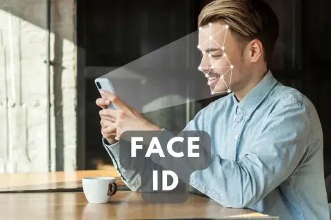 Uśmiechnięty mężczyzna korzysta z telefonu, który skanuje jego twarz. Technologia Face ID zapewnia szybki dostęp.