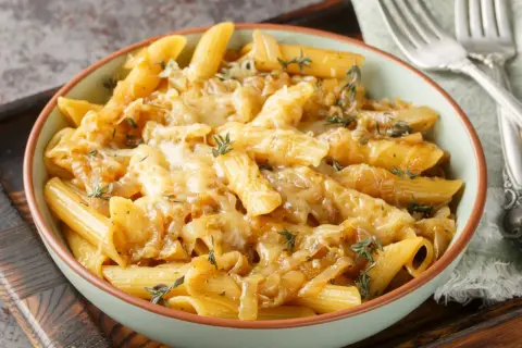 Penne z karmelizowaną cebulą i serem, idealne jako jaki sos do makaronu z warzywami.