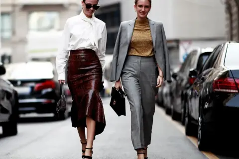 Eleganckie stylizacje, które zainspirują, jak się ubrać na obronę pracy magisterskiej. Jedna w skórzanej spódnicy, druga w garniturze.