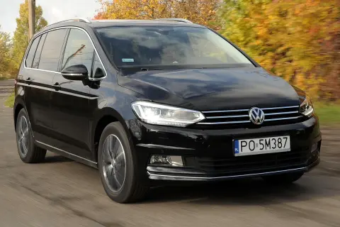 Czarny Volkswagen Touran 1.9 TDI 105 KM szarpie przy przyspieszaniu, jadąc po drodze wśród jesiennych drzew.