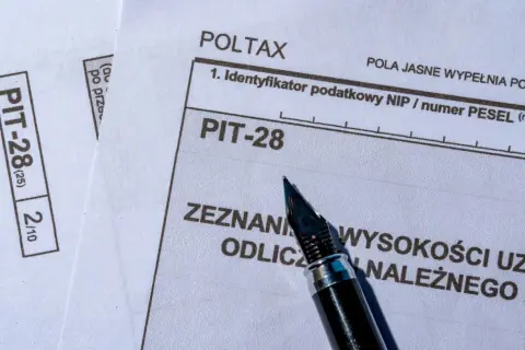 Formularz PIT-28, który służy do rozliczenia przychodów z najmu, leży obok pióra.