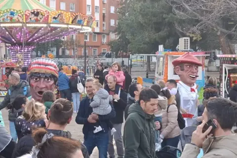 Gigantes y cabezudos animan las fiestas San José Zaragoza. Un carrusel y puestos de feria completan la escena festiva.
