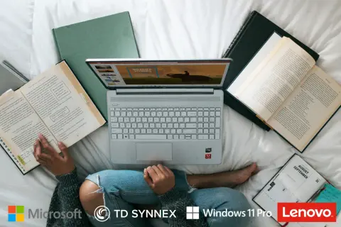 Osoba korzysta z laptopa z systemem Windows 10, otoczona książkami i notatnikiem.